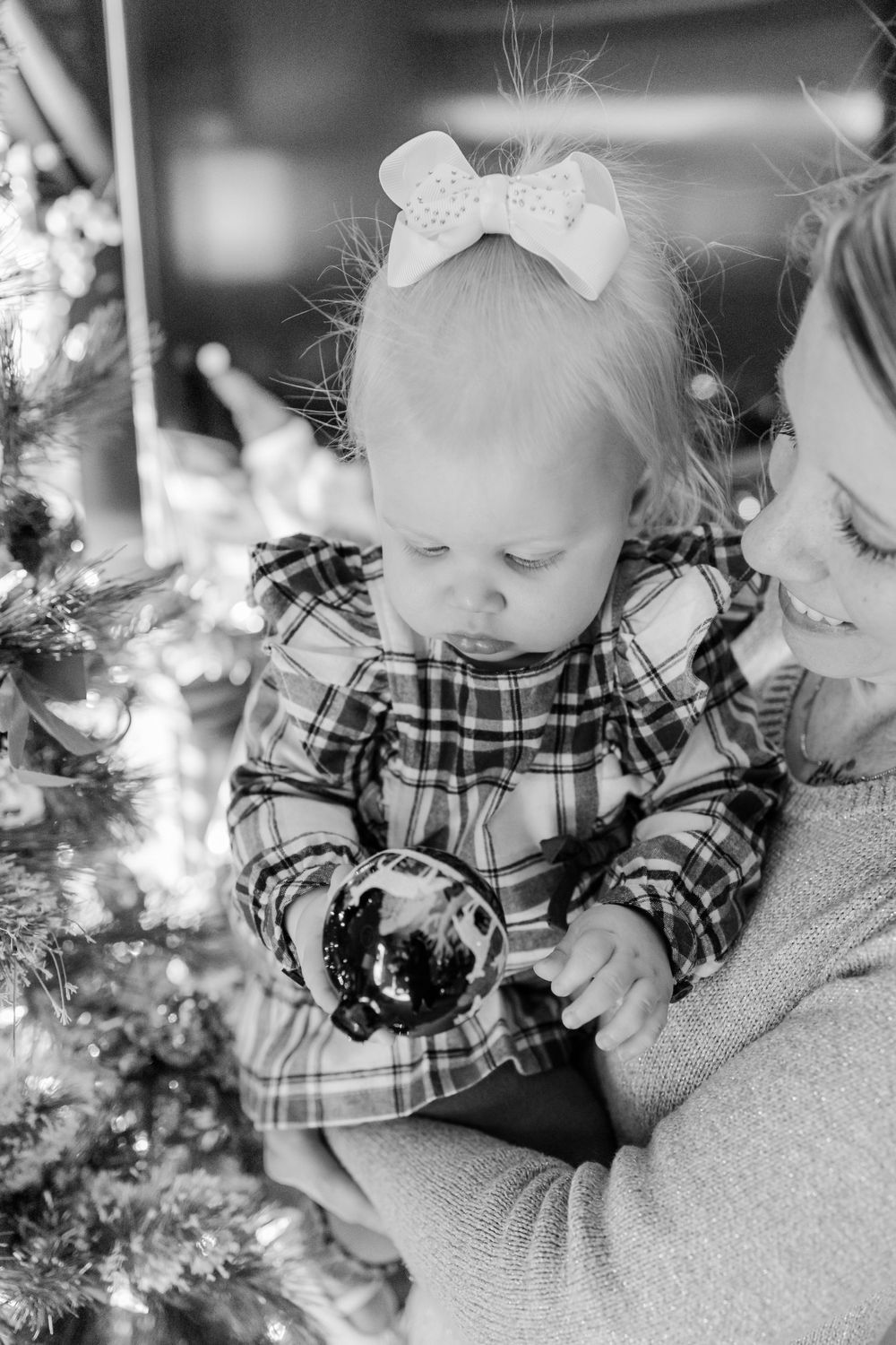 baby looking at christmas tree ornament