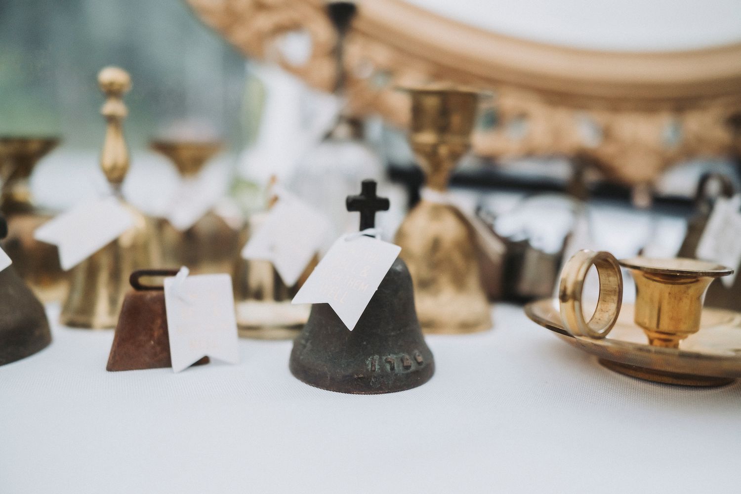 Beautiful vintage bells sitting on a wedding reception table. In the foreground a bell is marked with the year 1786.