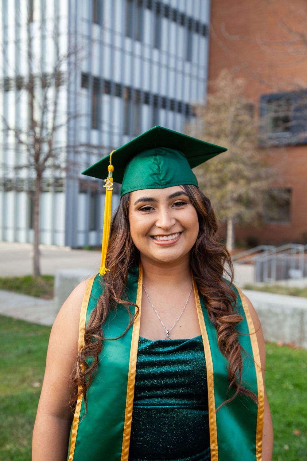 Graduate standing by Cal Poly building.