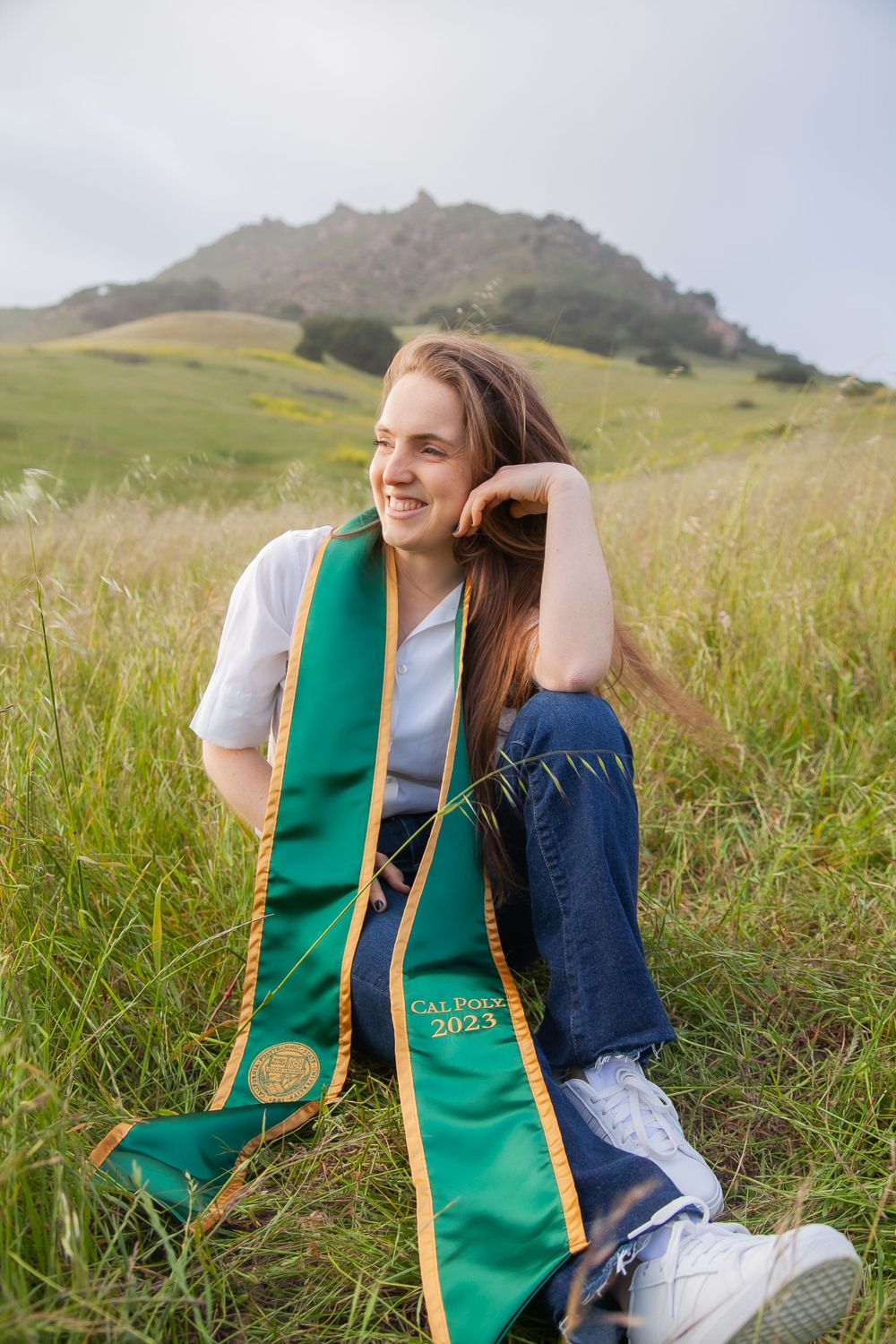 Graduate sitting by Bishop Peak.