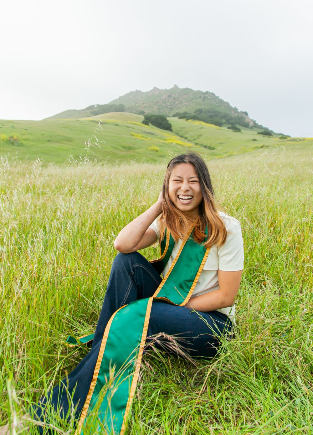 Graduate sitting by Bishop Peak.
