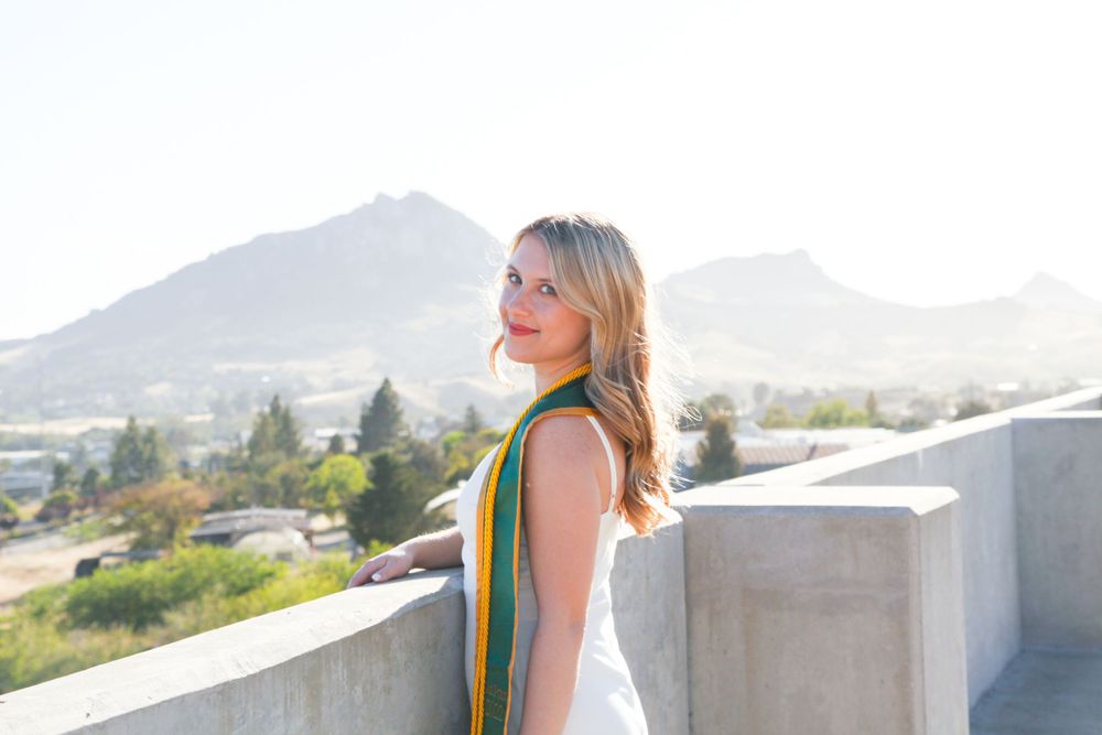Graduate standing on top of Cal Poly parking lot.