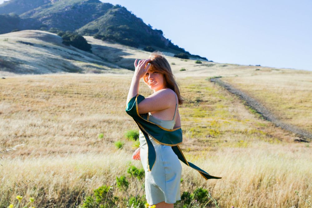 Graduate standing by Bishop Peak.