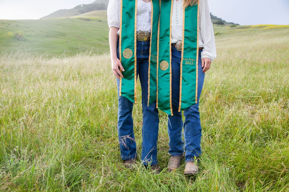Two graduates standing by Bishop Peak.