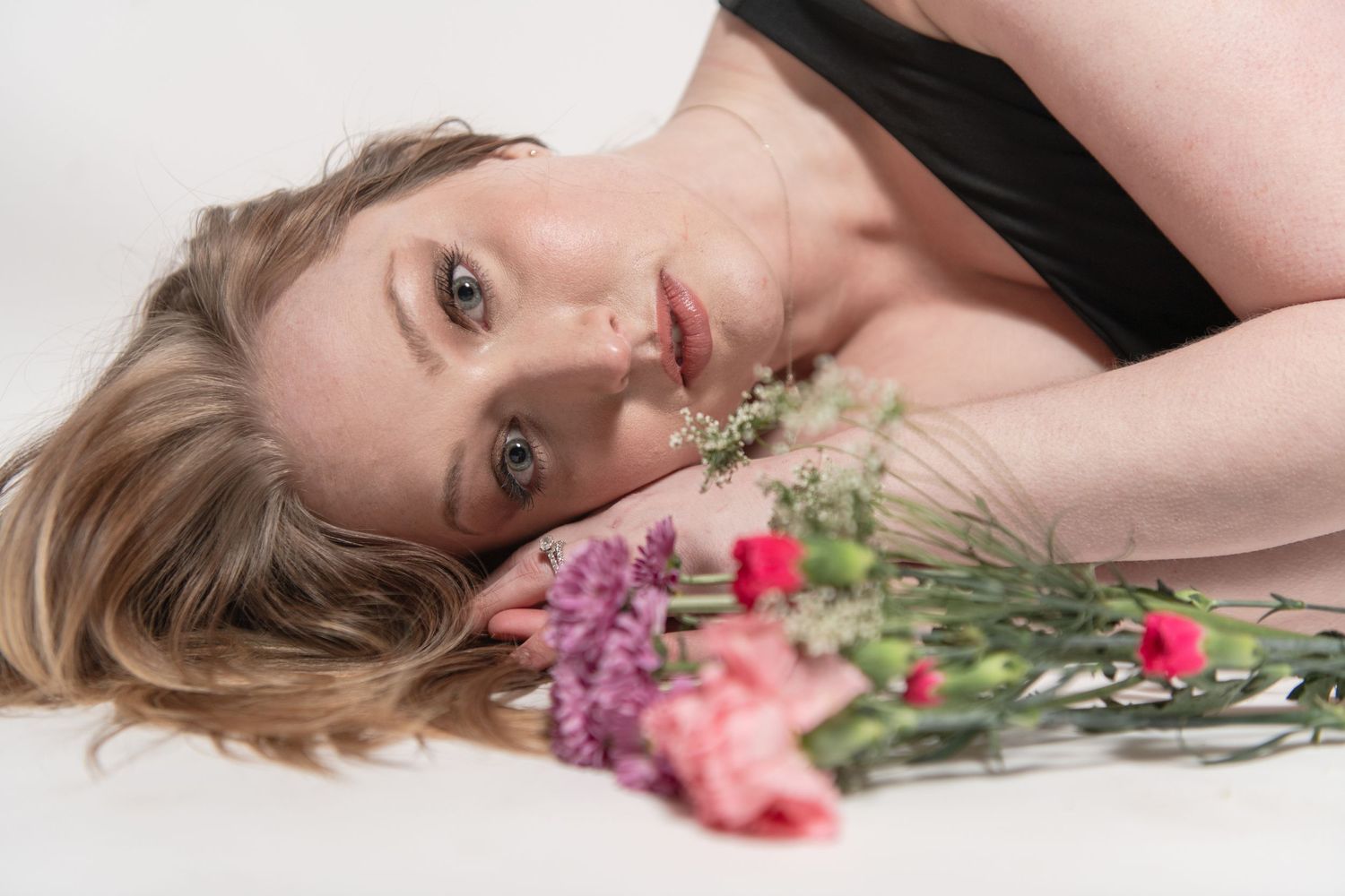 Artistic portrait with fresh flowers in soft natural lighting.