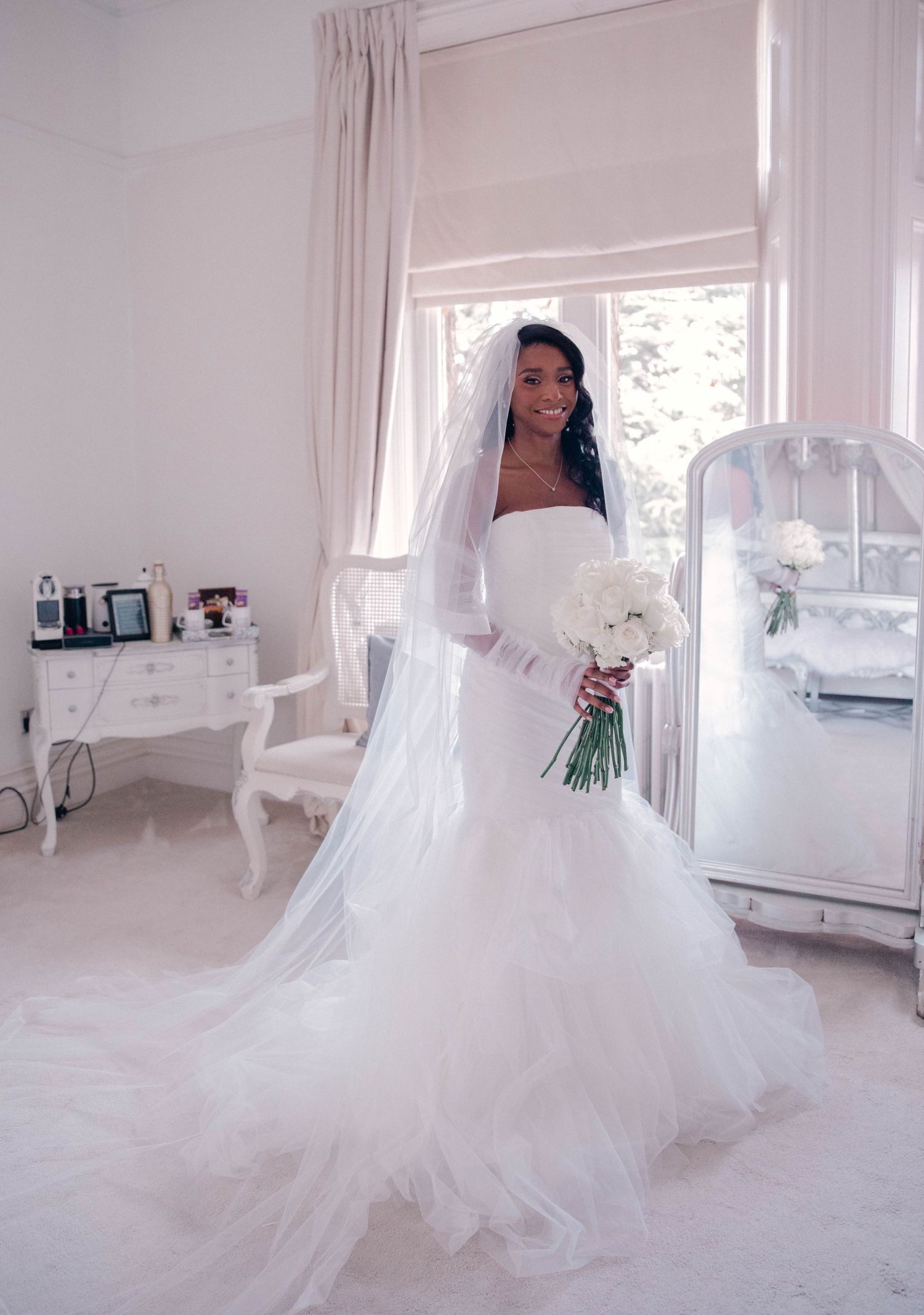 Bride twirling in a voluminous white wedding gown in a sunlit room.