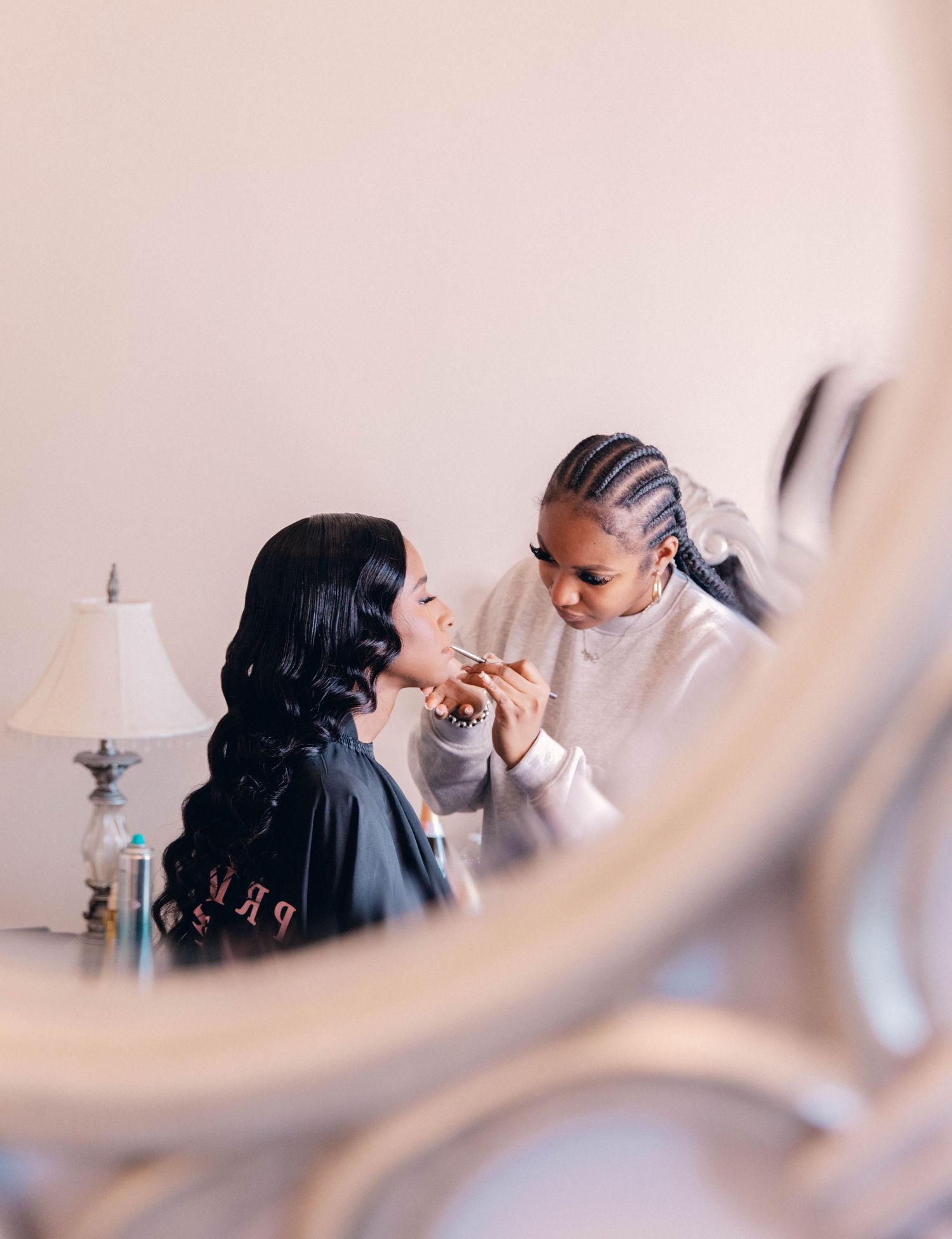 Professional makeup artist applying cosmetics in a bright studio setting.