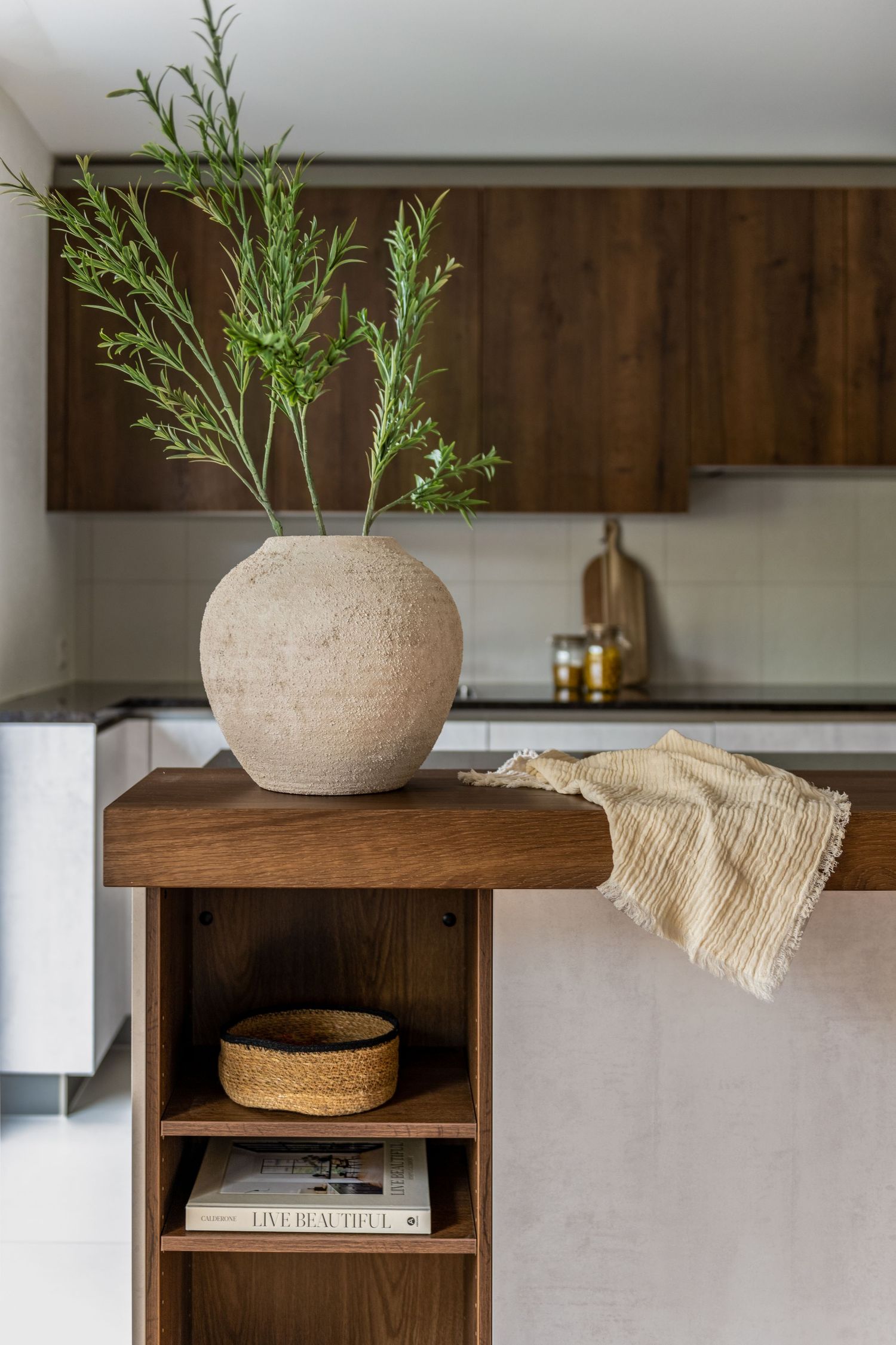 A ceramic vase with green foliage in a wooden kitchen