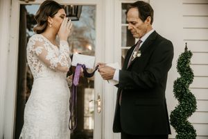 Tender moment shared on white porch during wedding ceremony.