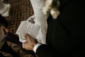Wedding ceremony detail showing handwritten vows being read.