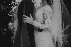 Black and white wedding photo capturing an intimate moment between newlyweds with vintage-inspired styling.