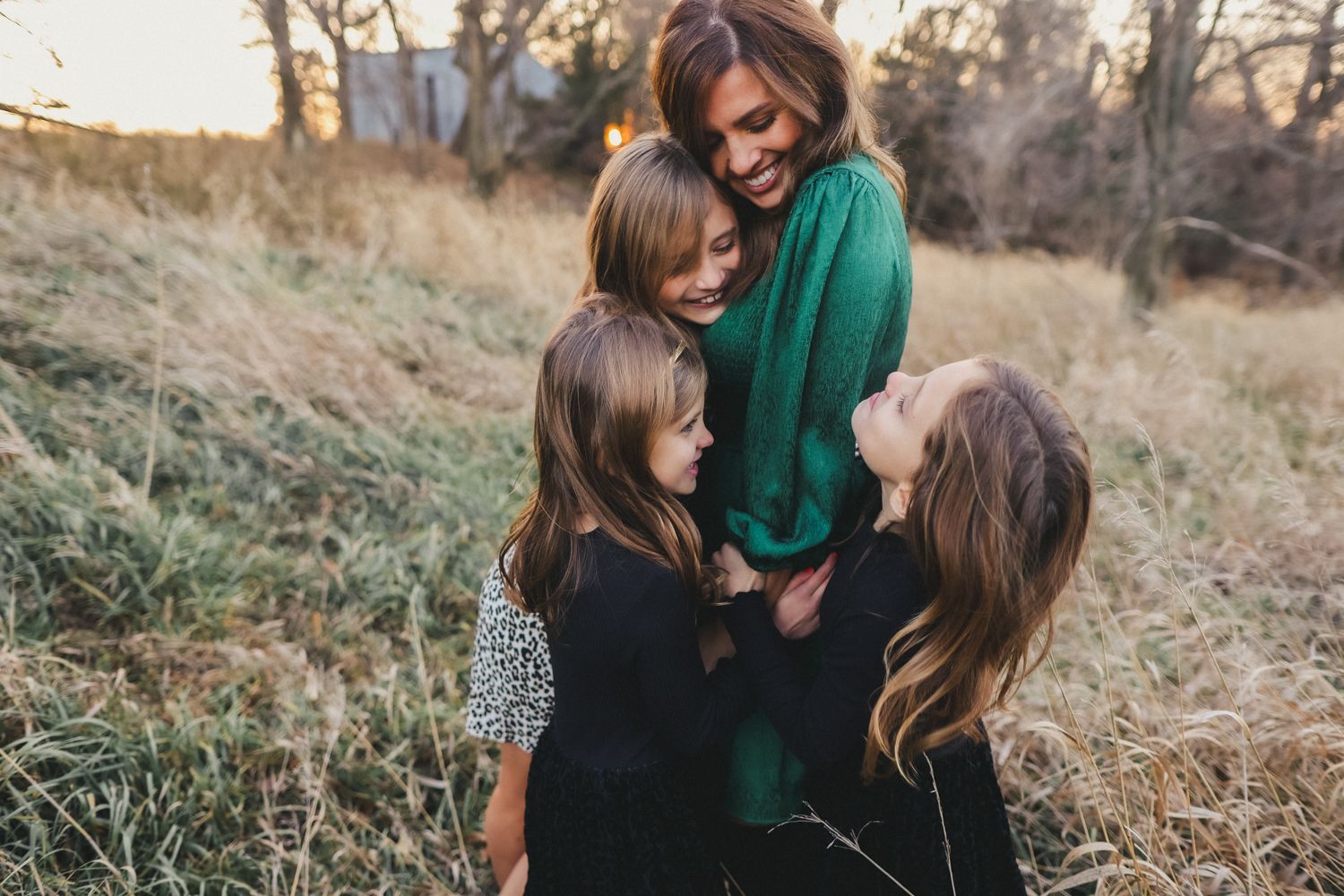 Group sharing joyful laughter while sitting together in autumn grass.