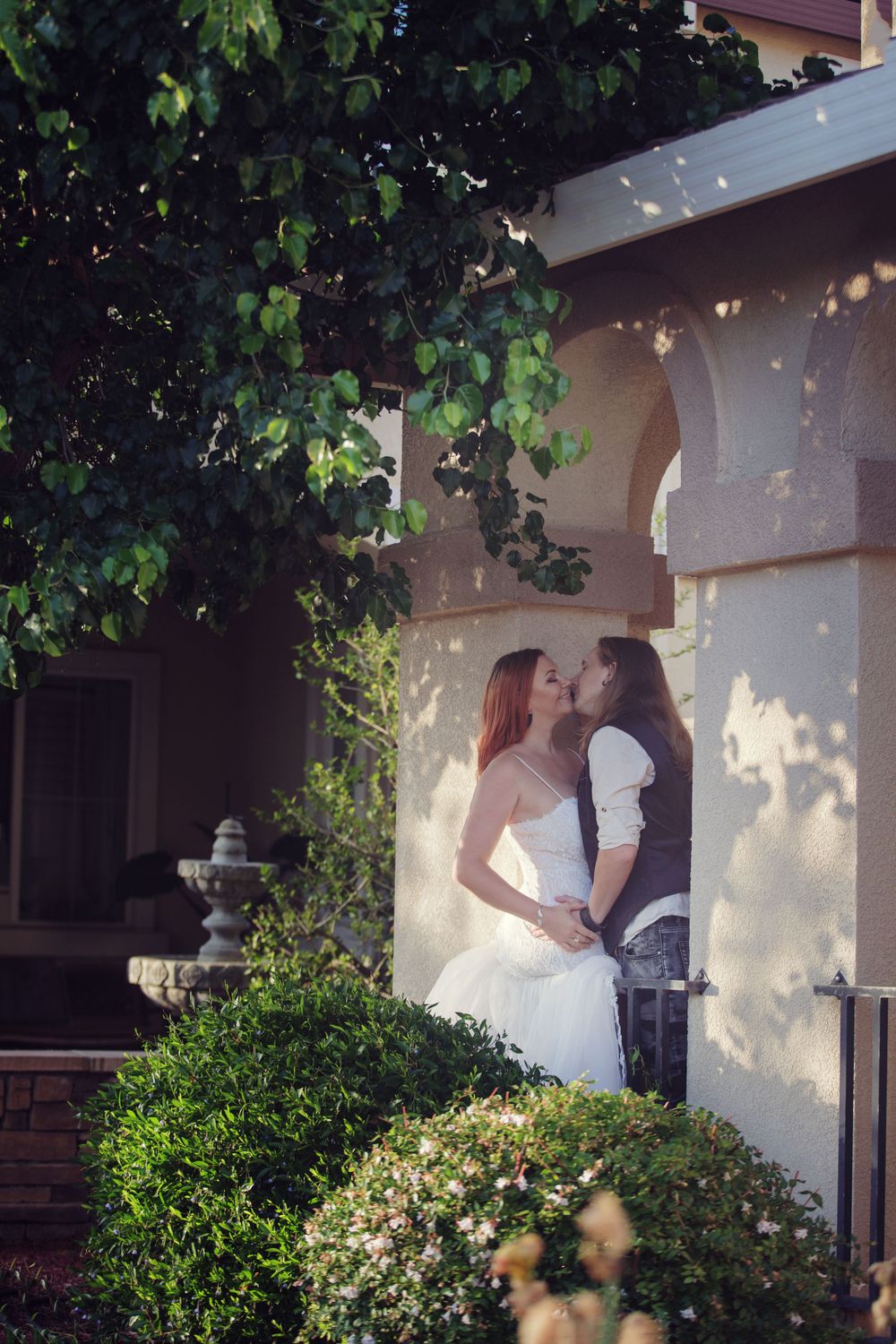 Romantic wedding couple under an outdoor arch, natural light wedding photography