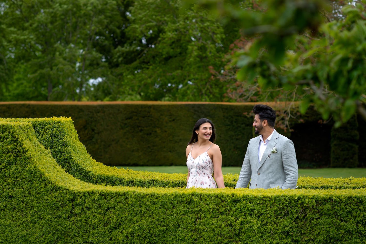 Elegant wedding photo session along manicured garden hedges.