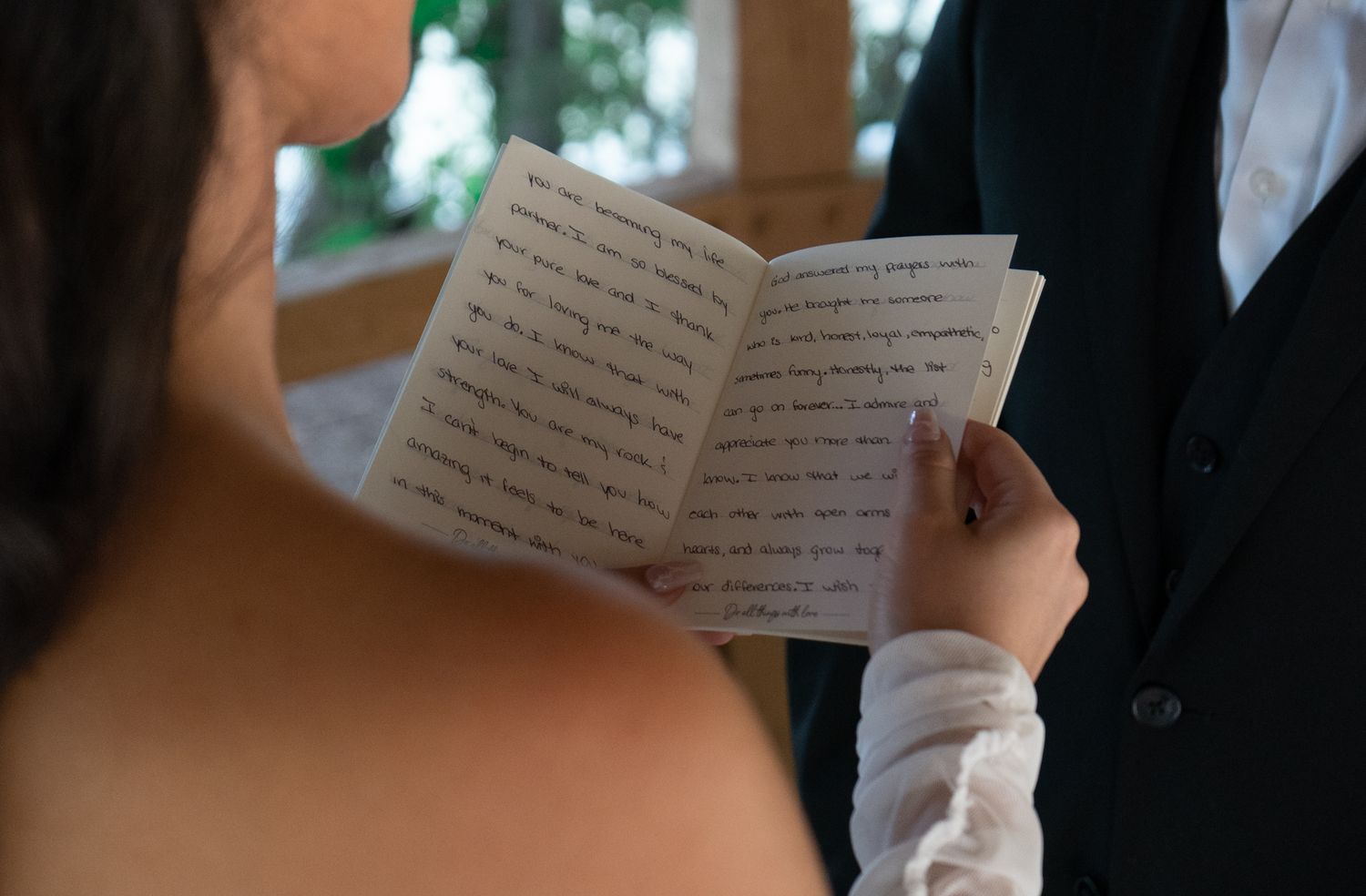 Wedding ceremony with people reading from handwritten vows during the service.
