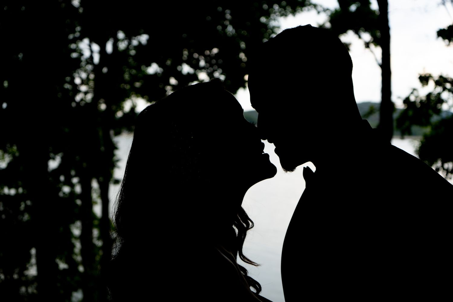 Silhouette sequence of a couple in romantic poses against a dark background.