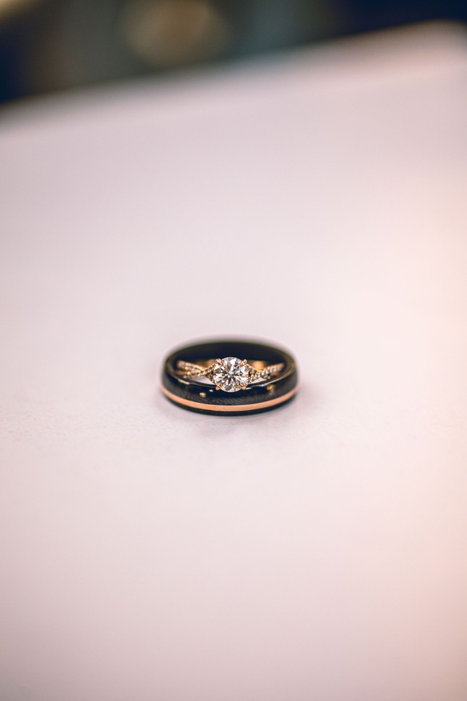 Close-up shot of elegant wedding rings with diamond details on white surface.