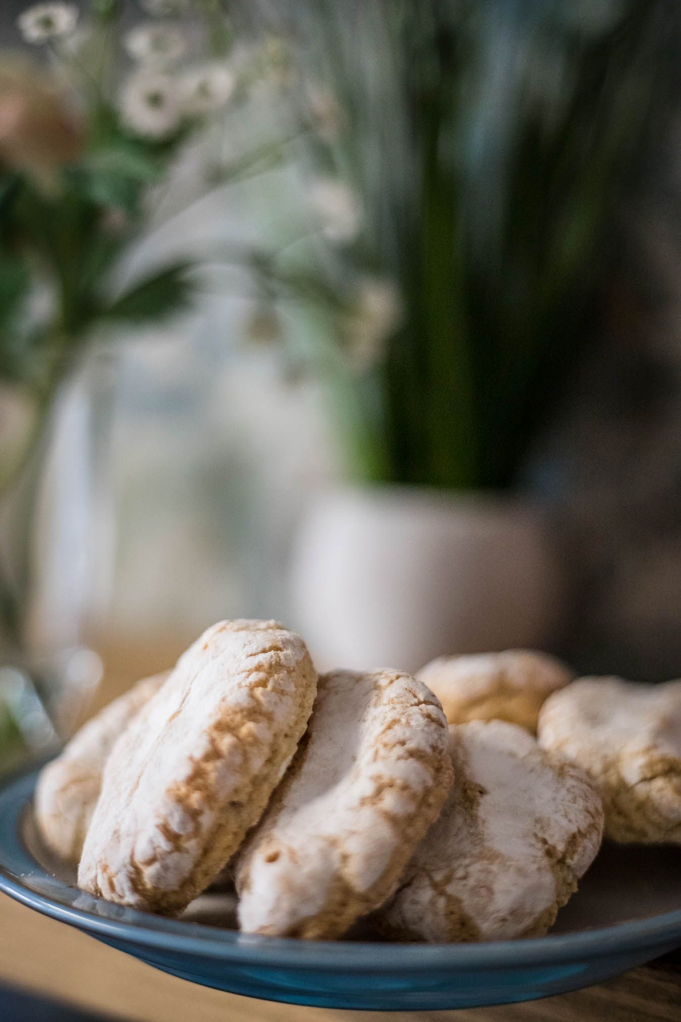 Image of homemade cookies on a plate next to a vase of flowers