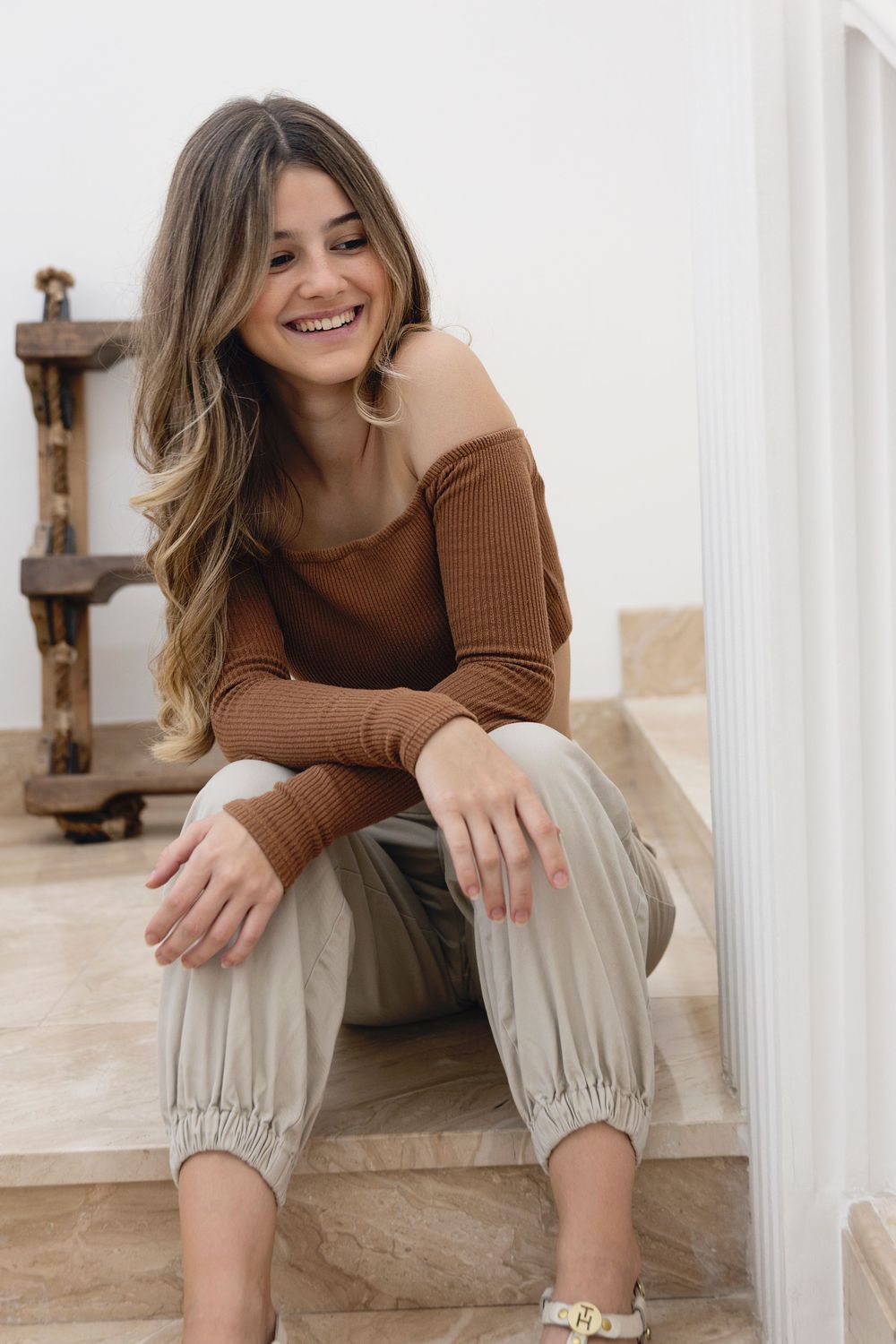 Senior girl sitting on the stairs and having a laugh during a senior portrait session.