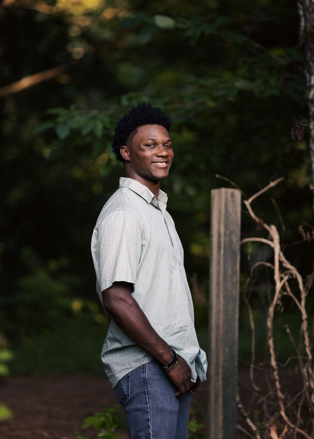 A candid outdoor portrait showing joy and happiness against a natural forest backdrop.