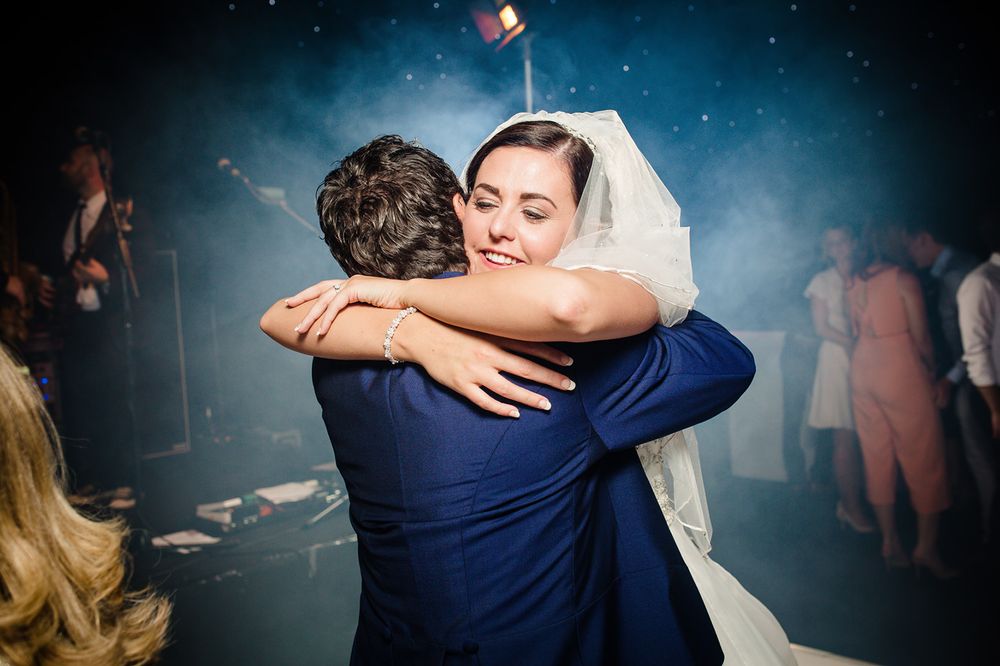 A bride hugs her father and smiles after their dance on the day of her wedding at Thornton Manor
