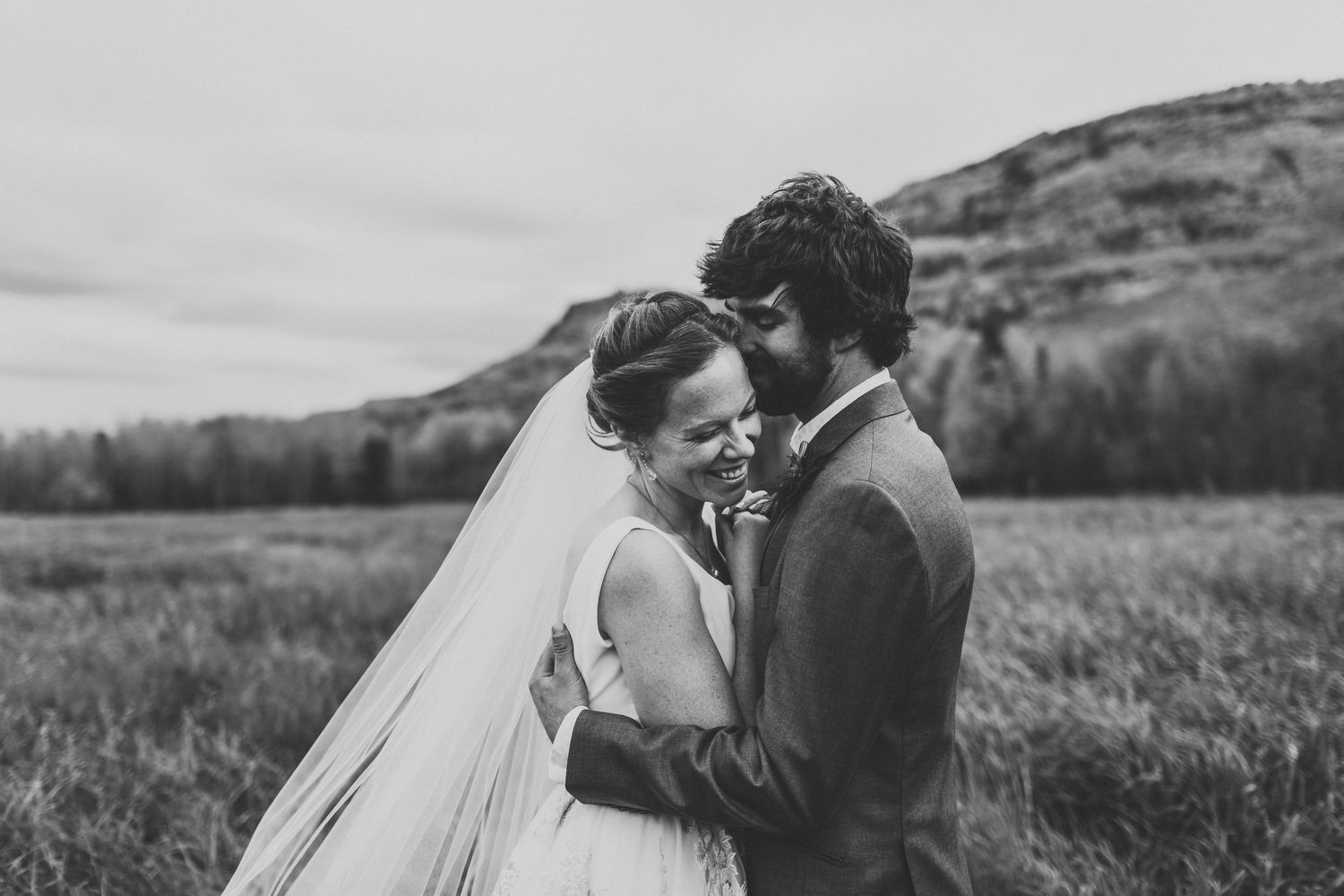 A bride and groom hug closely on their wedding day in Chetwynd BC