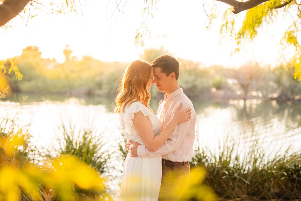 A romantic sunset moment near a tranquil lake with soft golden lighting.