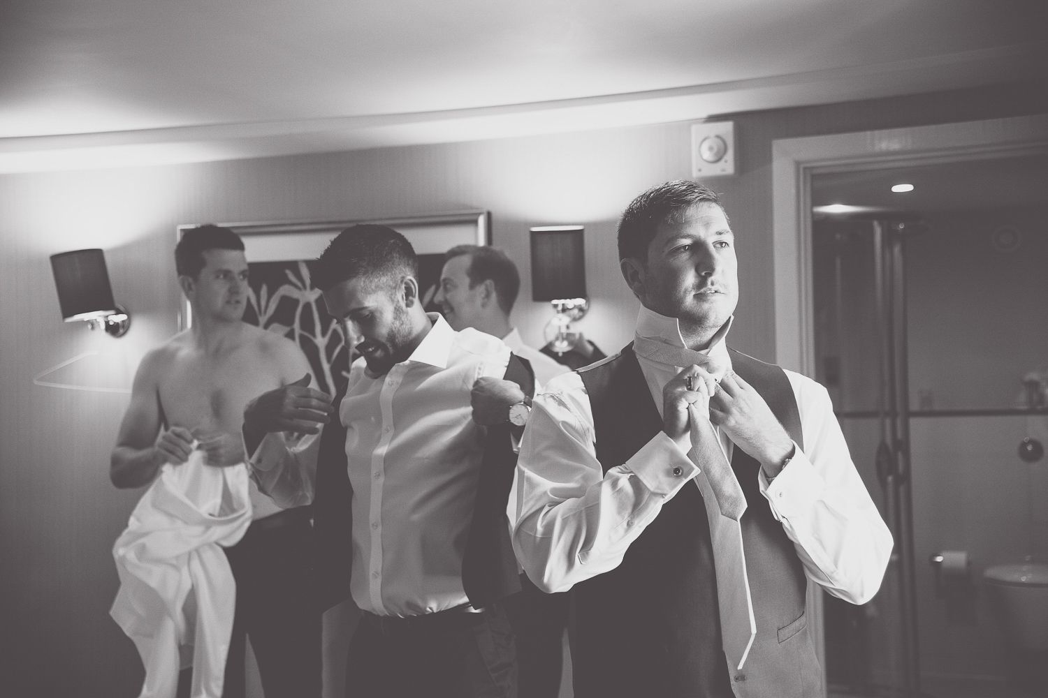A candid black and white photo of formal attire preparations before a wedding ceremony.
