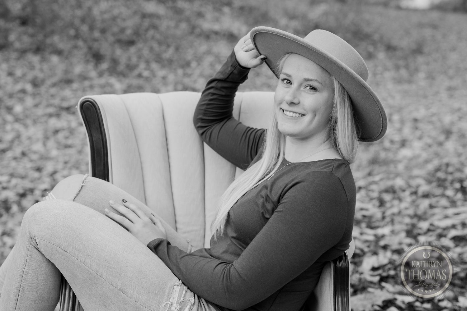 Black and white portrait in vintage armchair with casual fall attire.