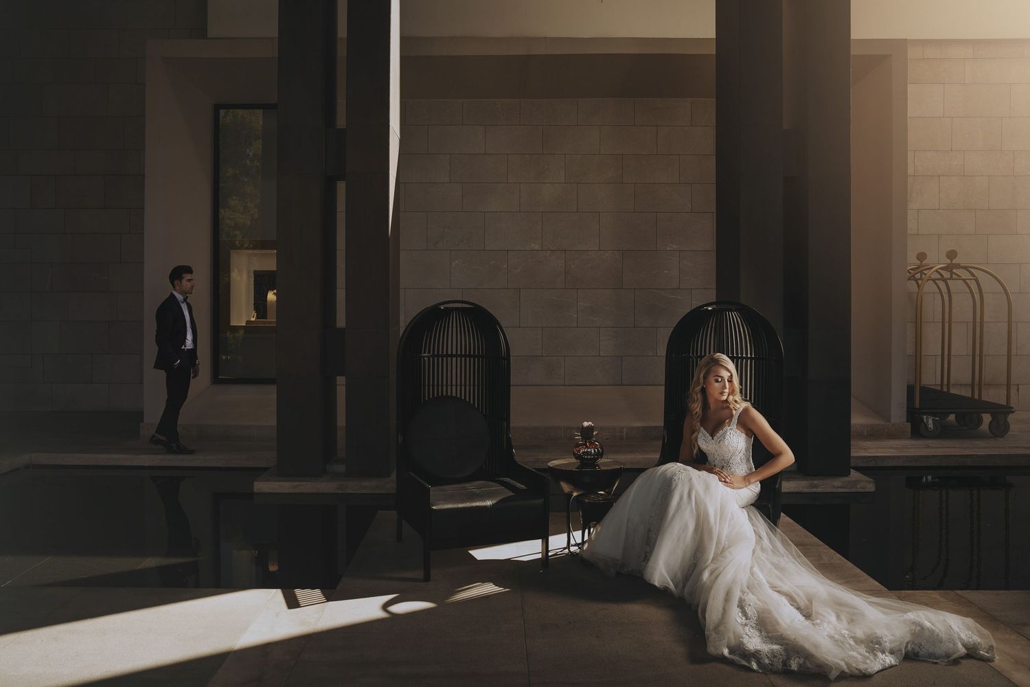 Moody indoor wedding portraits with dramatic lighting in minimalist hallway.