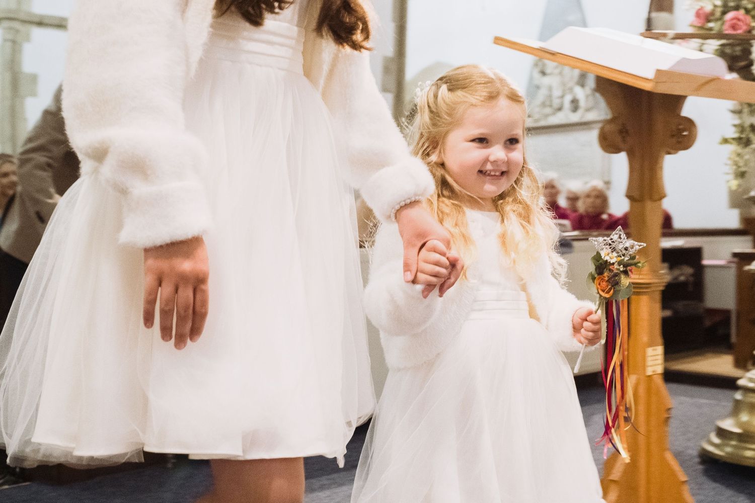 Young bridesmaid walks down the aisle of a church