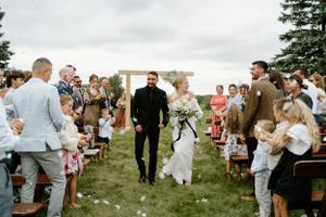 Smiling newly married Bride and groom walking up the isle taken by Alexis Anne Photography