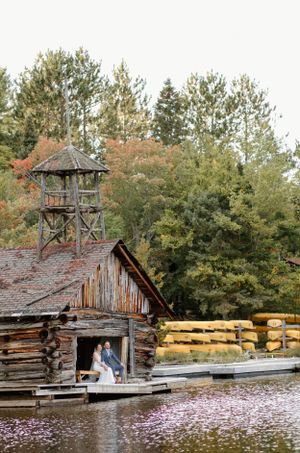 Bride and groom sitting on the dock of the old boat house at camp Arowhon Algonquin Provincial Park-Alexis Anne Photography
