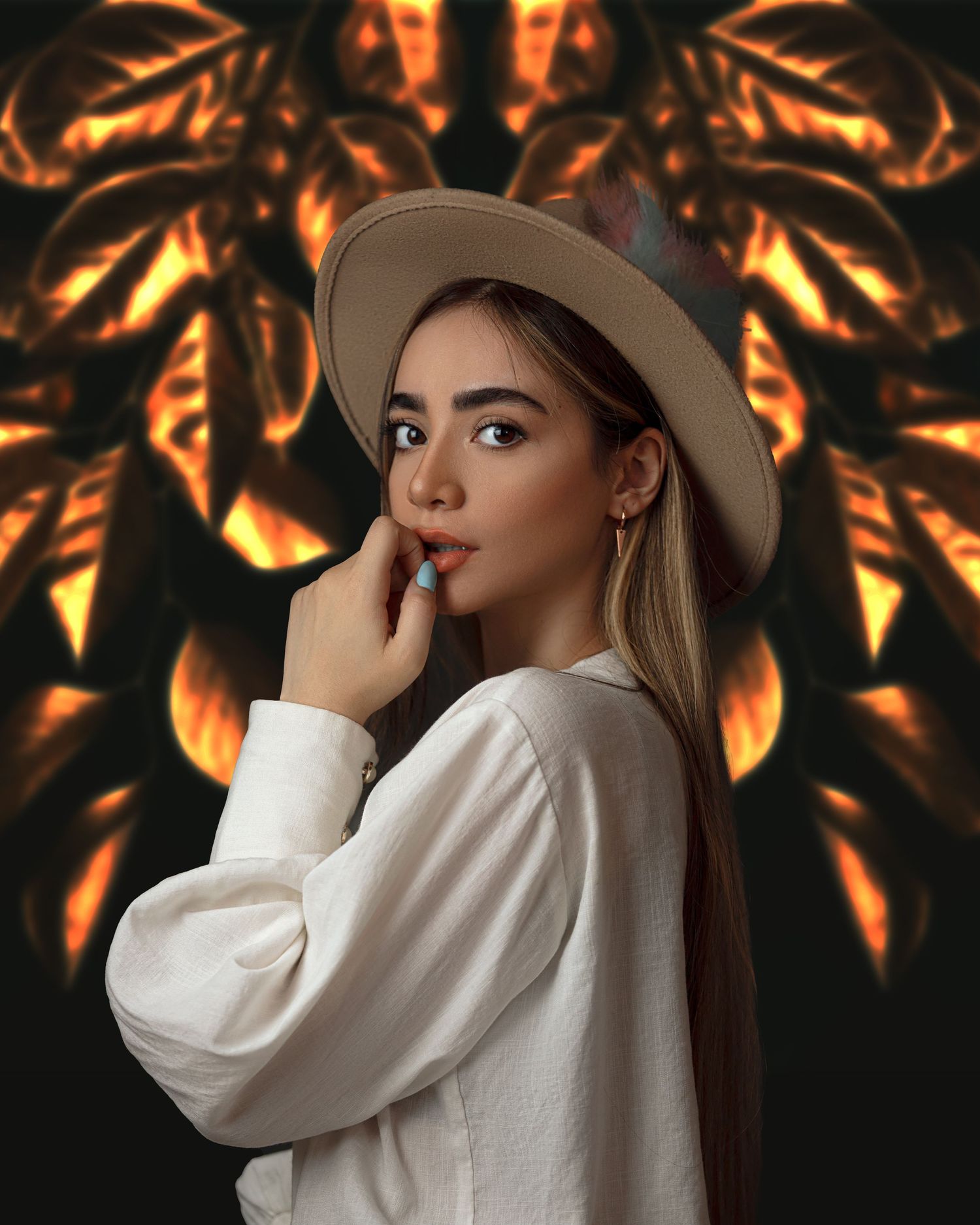Fashion portrait against orange floral background features model in white sweater and beige hat with dramatic lighting.