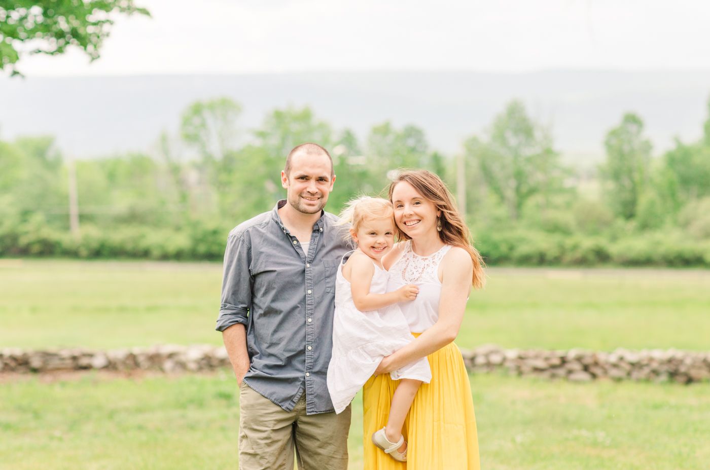 Portrait of a family of three with mountains in the background during a photo session with Danielle Lauren Photography