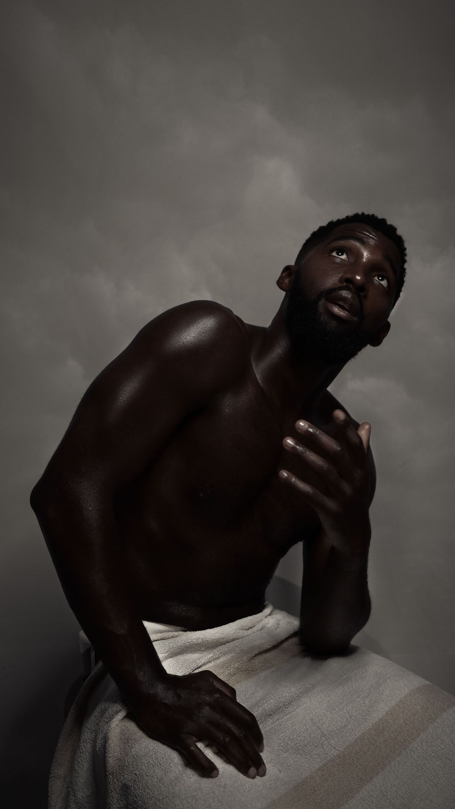 Artistic black and white portrait with dramatic lighting and white fabric.