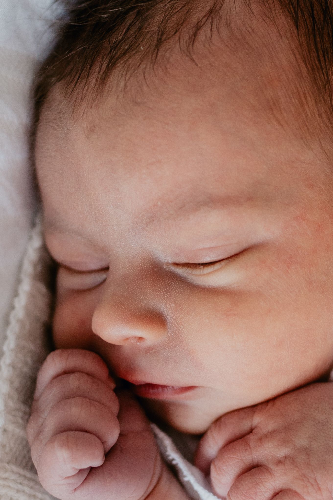 Close up of sleeping newborn baby's peaceful face and delicate features.