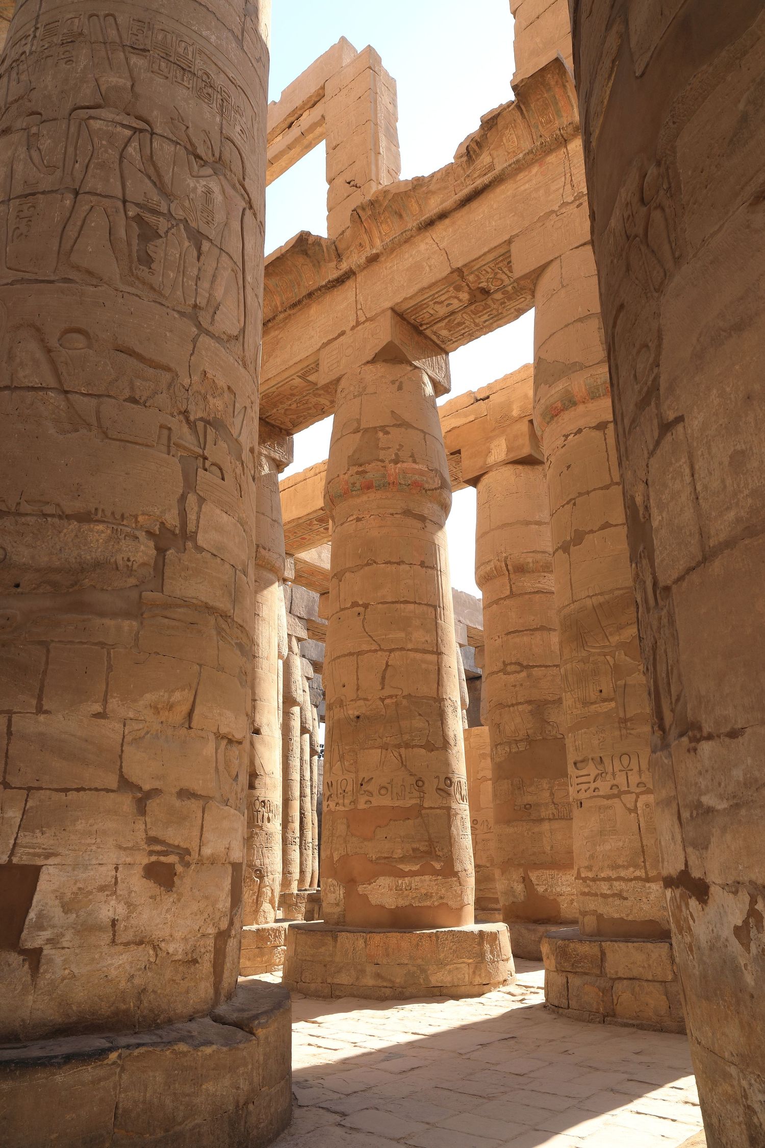 Massive stone columns and architecture inside ancient Egyptian temple complex.