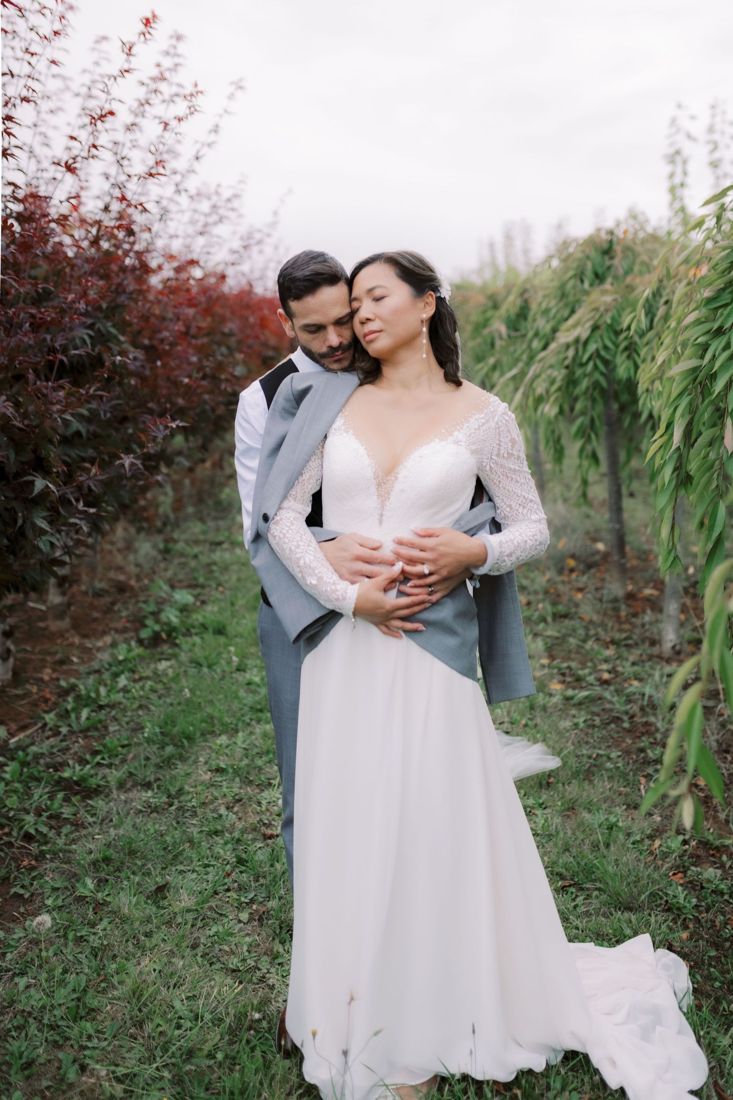 A romantic embrace between newlyweds in an autumn vineyard setting.