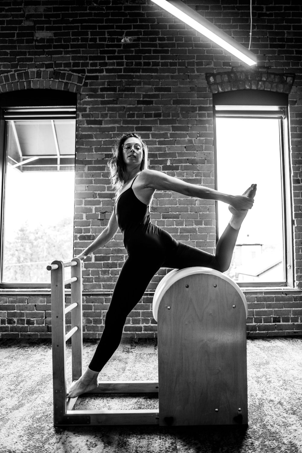 Artistic black and white photos of dancer performing dynamic movements against brick wall.