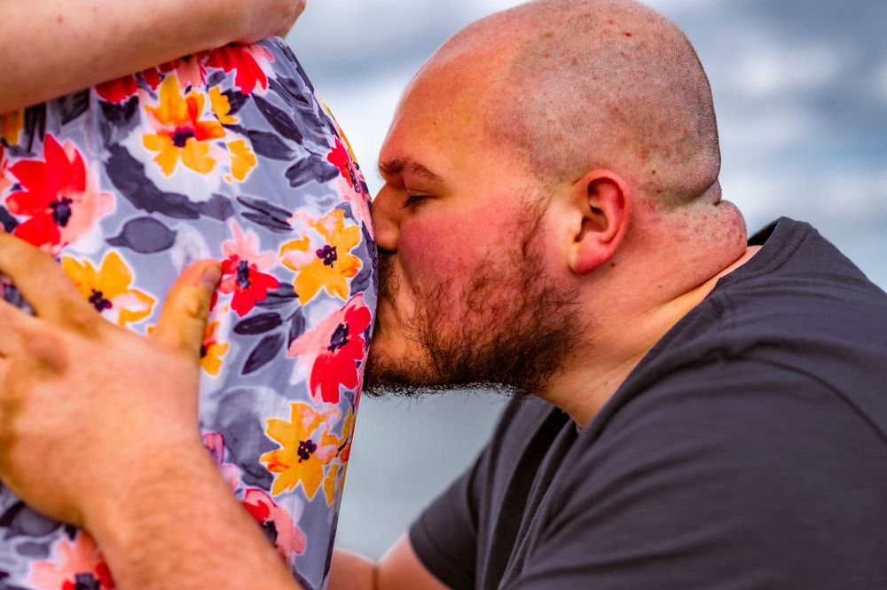 An intimate moment captured against a floral dress backdrop.