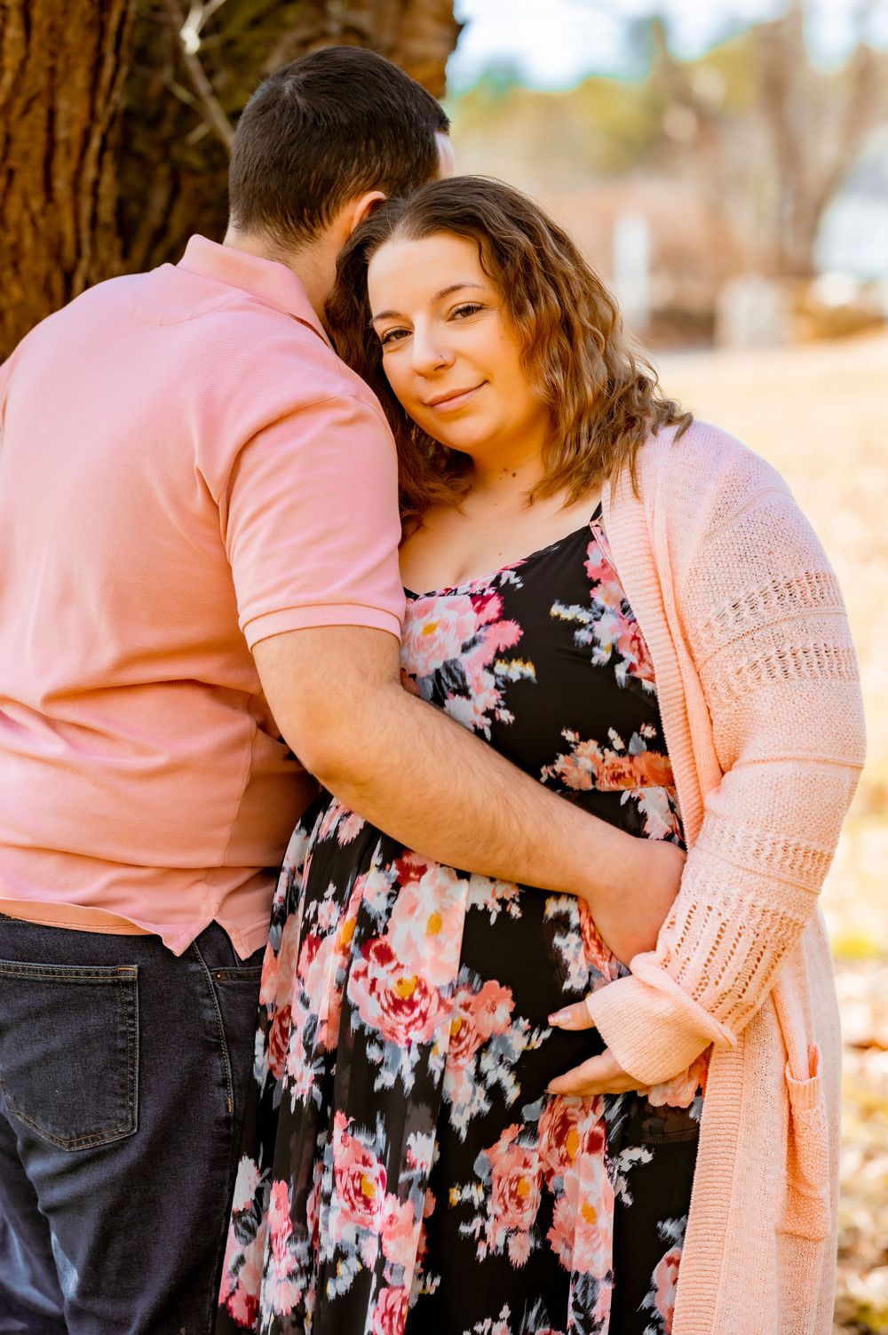 A tender moment captured between a couple in pink and floral attire.