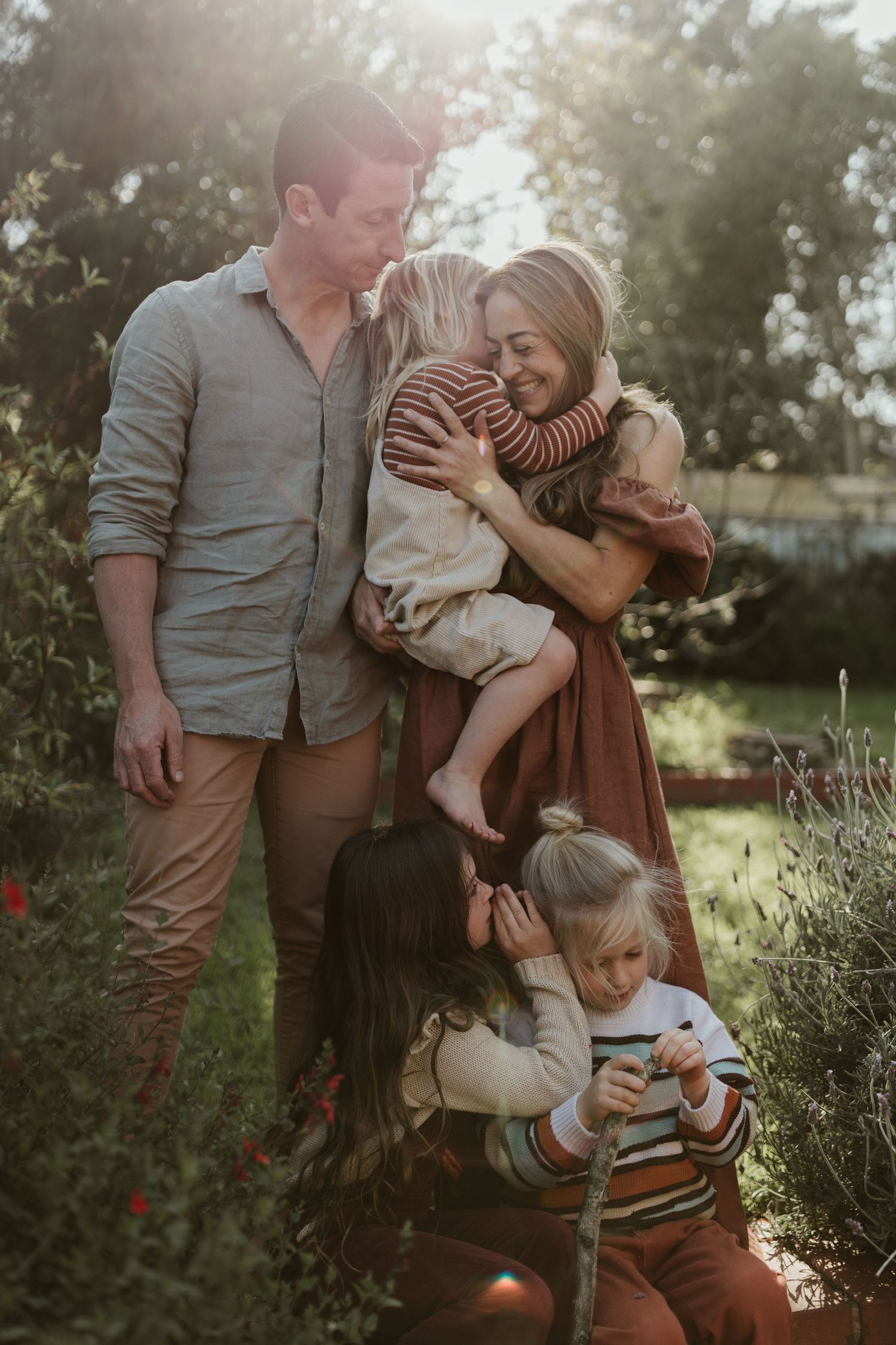 Family cuddling during a photoshoot in their back garden