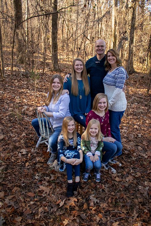 family posing for a family portrait in the woods