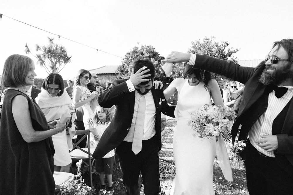 A joyful black and white candid moment during wedding celebrations.