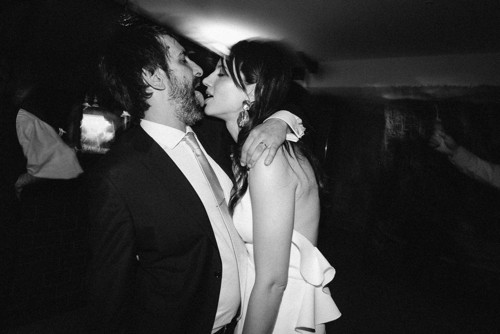 A black and white photo captures an intimate dance moment at a wedding reception.