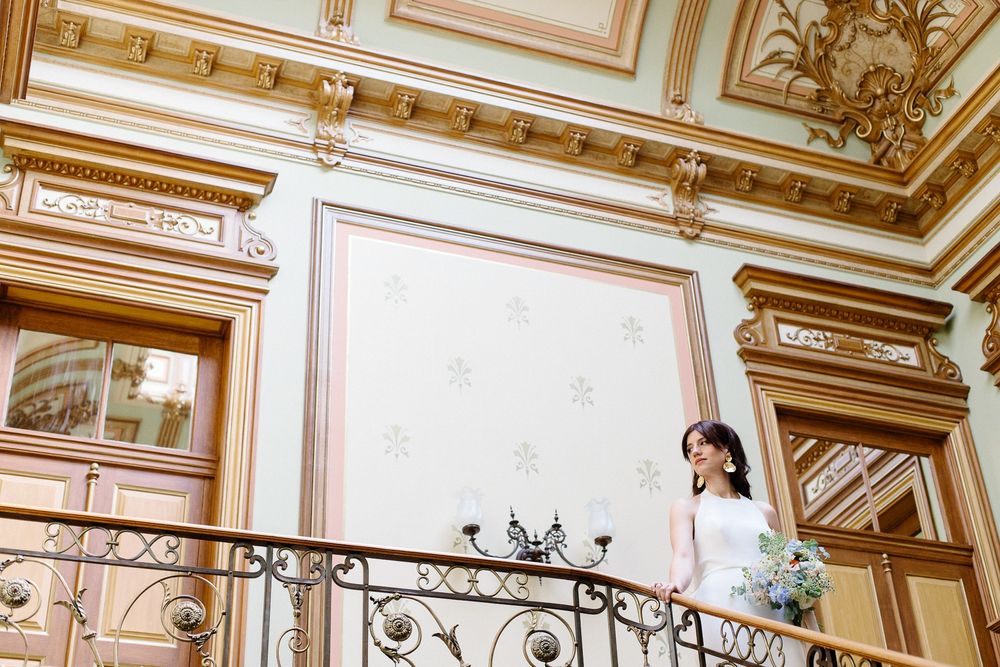 Classic architectural wedding venue featuring ornate moldings and wrought iron balcony details.