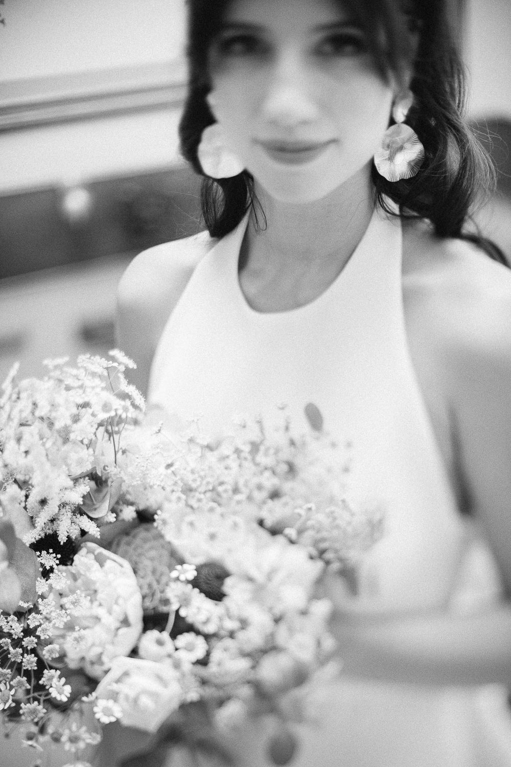 Black and white photograph of delicate bridal bouquet with soft floral details.