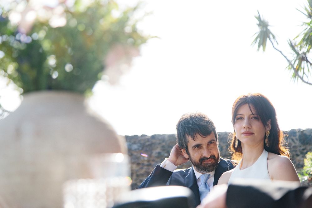 A sunny outdoor wedding moment captured during a ceremony with floral decorations.