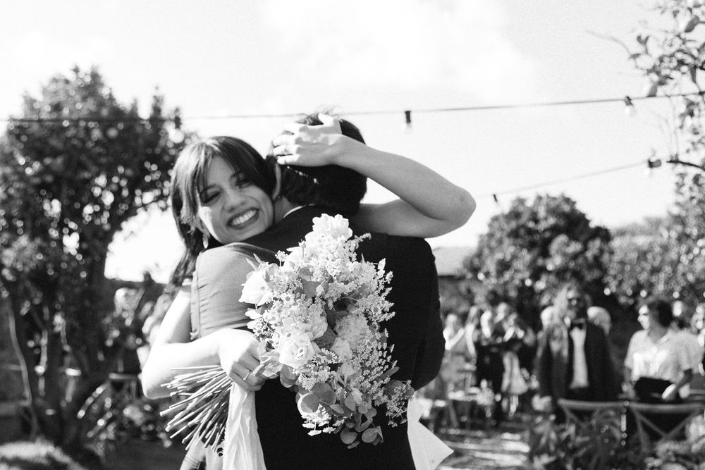 A candid black and white photo capturing pure joy during wedding festivities.